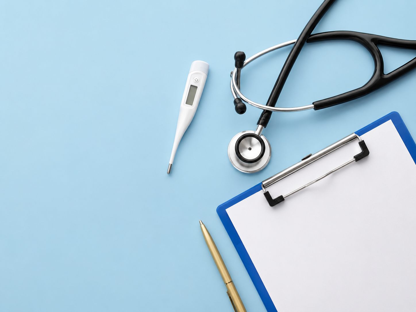 Medical tools — stethoscope, thermometer, and clipboard — laid out on a soft blue surface